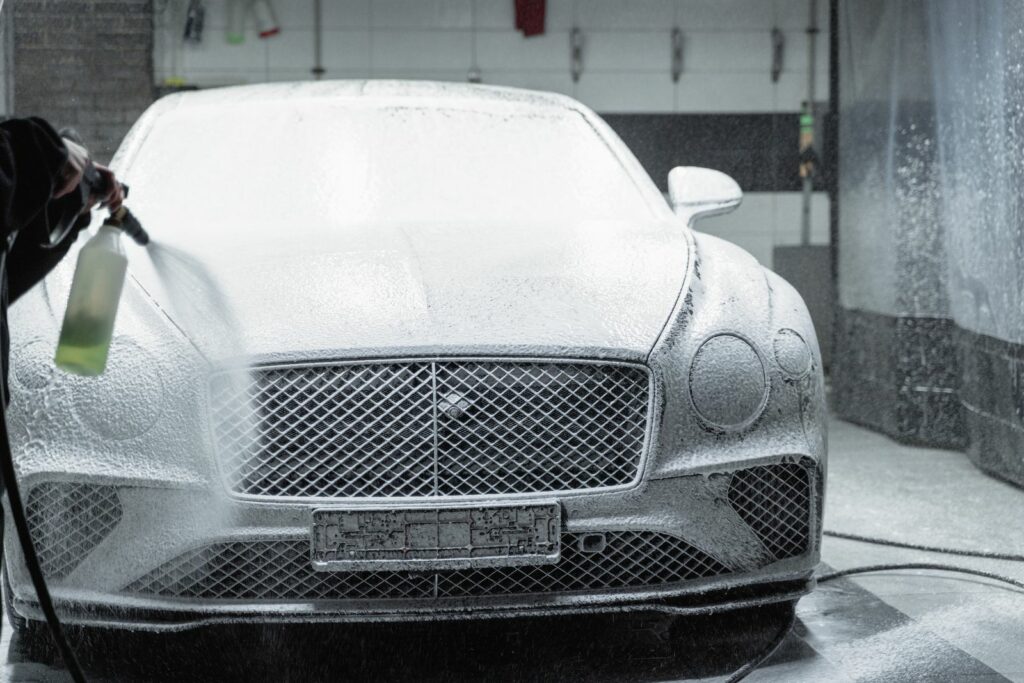 Laver sa voiture sans rayures : carrosserie recouverte de mousse active en atelier de detailing